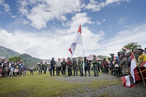 Bersama Masyarakat, Satgas Yonif 715/Motuliato dan Apkam Puncak Jaya Kibarkan Bendera Merah Putih Raksasa di Momen Tanggal 1 Mei 2025