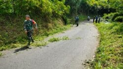 Sinergi Tanpa Batas, Babinsa Sidorejo Bersama Warga Bersihkan Rumput Tebing Demi Keselamatan Penguna Jalan