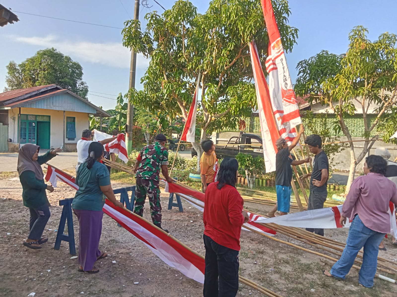 Semangat Gotong Royong Sambut HUT ke-81 RI, Babinsa Koramil 0908-01/Loktuan Bersama Warga Pasang Bendera dan Umbul-Umbul